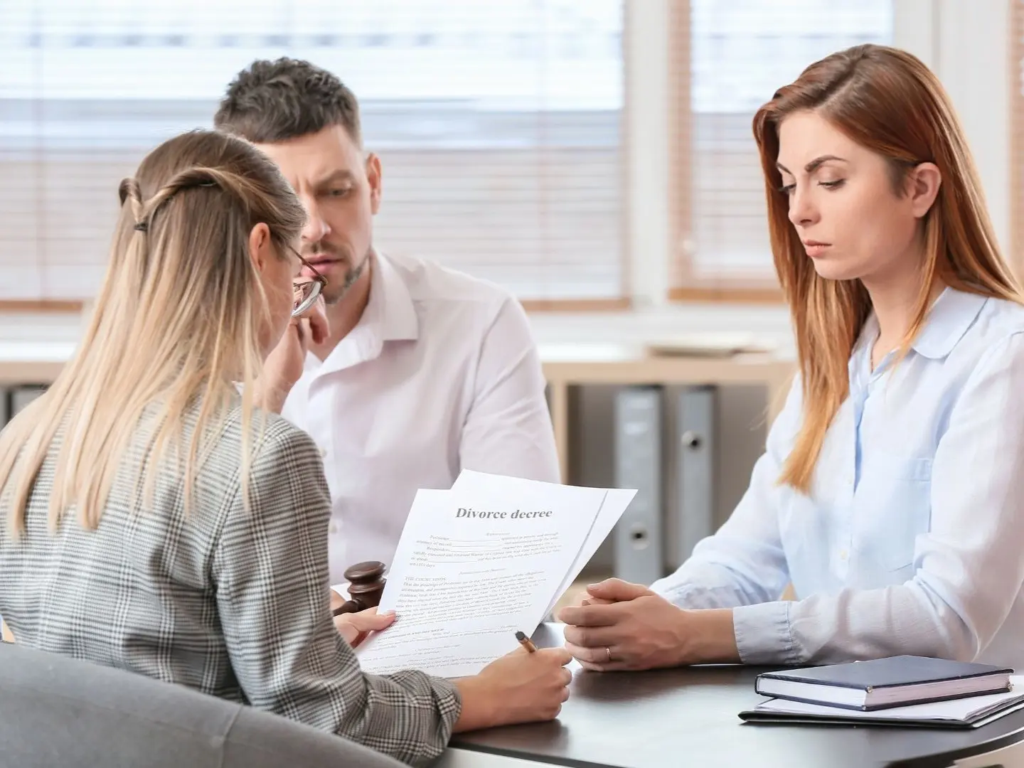 Spouses meeting with a collaborative divorce attorney in Syracuse, NY to review divorce settlement documents